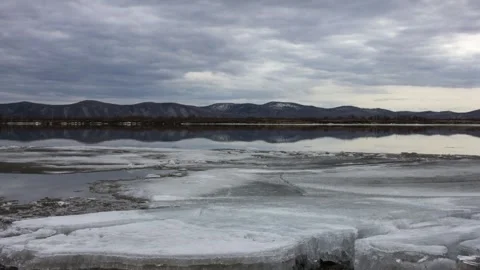 Timelapse of ice drift on a river with mountains at the background Stock Footage 144277607