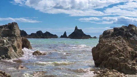 Timelapse Incoming waves puffy clouds passing in blue sky dramatic rock Stock Footage 339019939