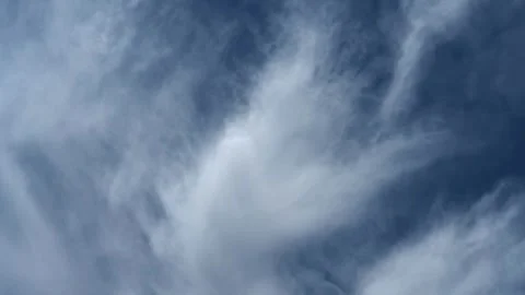 Timelapse of interesting white to light-blue clouds drifting through a bright Stock Footage 310690626
