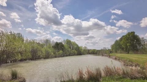 Timelapse of irrigation pond with fast moving clouds in country setting Stockbeeldmateriaal 337180345