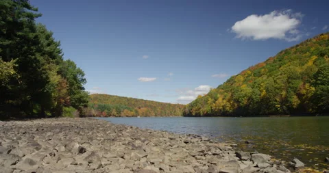 A timelapse of a lake and fall trees on mountains Stock Footage 144985874