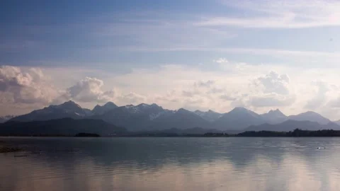 Timelapse of a lake called "Forggensee" with the german Alps in the background Stock Footage