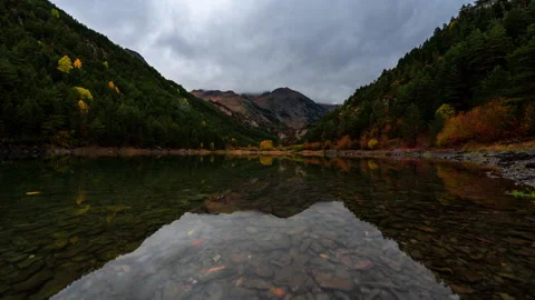 Timelapse of lake in Pyrenees during colourful autumn and moody clouds Stock Footage 164572258