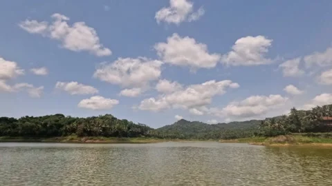 Timelapse of a lake view with a blue sky and white clouds in the background Stock Footage 323149239