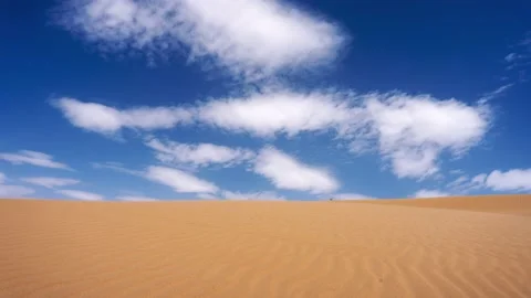 Timelapse of landscape with clouds flowing in a sunlit sky in the desert Stock Footage 230030184