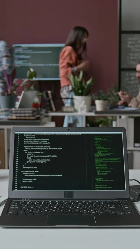 Timelapse of Laptop with Running Lines of Code on Desk at Busy IT Startup Stock Footage 286073961