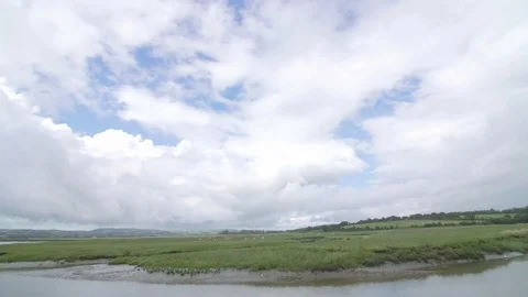 Timelapse of large clouds moving over marsh land Stock Footage 73559199