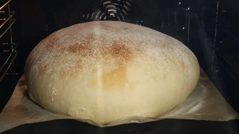 Timelapse of a large round loaf of white wheat bread baking in the oven 스톡 동영상 332122644
