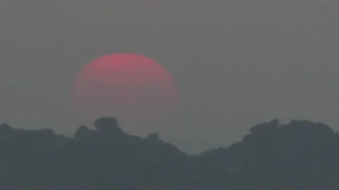 Timelapse, a large sun sets in orange clouds that turn blue. Stock Footage 155692304