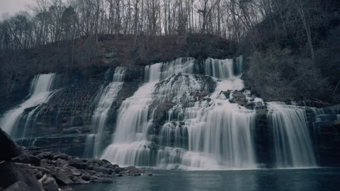 Timelapse of a large waterfall cascading down a cliff in the hills during winter Stock Footage 295709045