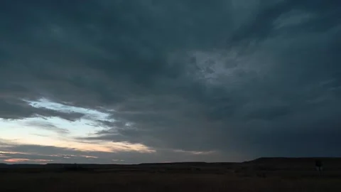 Timelapse of late day blue gray clouds drifting across a vast prairie landscape Stock Footage 333074866