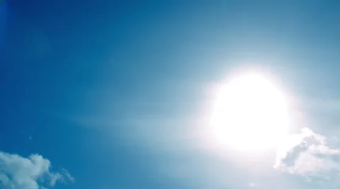 Timelapse of light clouds in an azure blue sky passing over the sun. Stock Footage 68351894