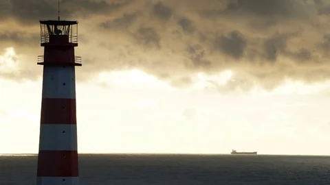 Timelapse lighthouse on the sea under stormy clouds and with the ship in the Видео 70525331