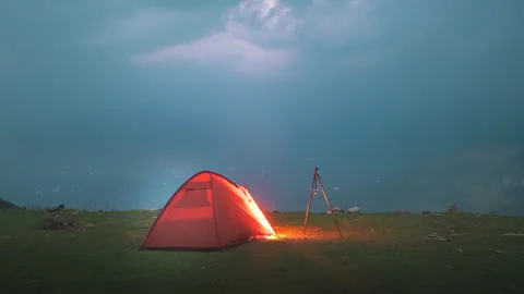 Timelapse of lightning illuminating the darkened sky over camping tent Stock Footage 241239457