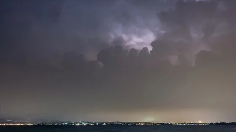 Timelapse of a lightning storm in the night over the city near Lake Garda Stock Footage 129067880