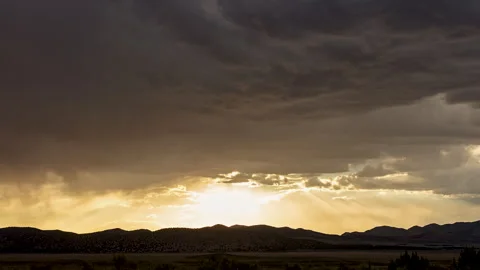 Timelapse looking over a valley towards the sun in the clouds Stock Footage 344604268