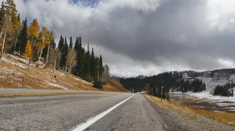 Timelapse-Low Angle-Clouds blow rapidly over empty road pines and golden aspen Stock Footage 68544974