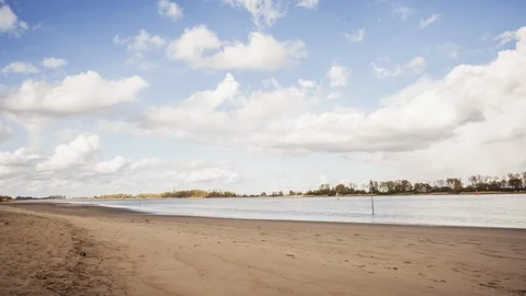 Timelapse of low lying clouds moving over river landscape with beach Stock Footage
