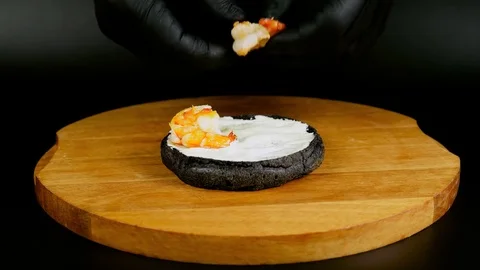 Timelapse of making a black seafood burger on wooden board Stock Footage 75253545
