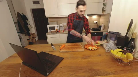 Timelapse man in apron cooking dinner in modern kitchen reading recipe from a la 스톡 동영상 143959577