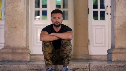 Timelapse of man sitting on the sidewalk in the crowd stream. The crowd is Stock Footage 80981816