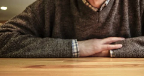 Timelapse of a man who sits at a table and talks, gesturing with his hands. Stock-Footage 129574199