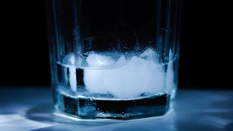 Timelapse of melting ice cubes in a glass with dramatic lighting Stock Footage 250082201