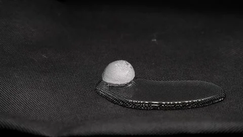 Timelapse of a melting piece of ice on a black background Stock Footage 339033875