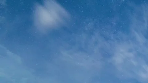 Timelapse of Milky Way in deep blue night sky with drifting clouds and glowing Stock Footage 320163048