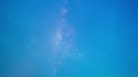 Timelapse of the Milky Way under a deep blue sky with scattered small clouds 스톡 동영상 317937939