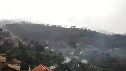 Timelapse - The mist dancing under the winter rain over a rural village. Stock-Footage 299864807