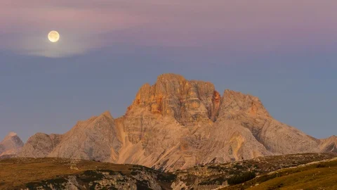 Timelapse of the moon hiding behind a mountain and colorful sky 動画素材 128733722