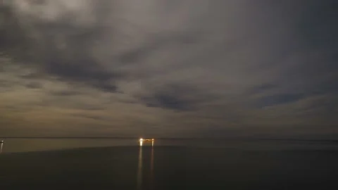 Timelapse of moonset over water with moving stars and clouds. Sunrise seascape 库存影片 148471366