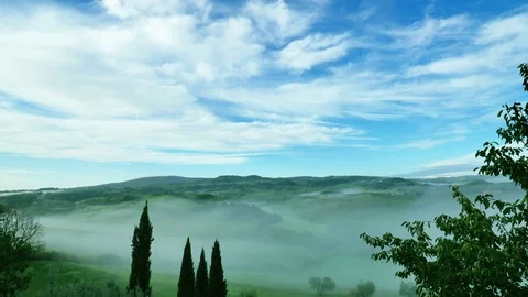 TIMELAPSE Morning fog descends on the magnificent meadow of Tuscany, fast Stock Footage 76768331