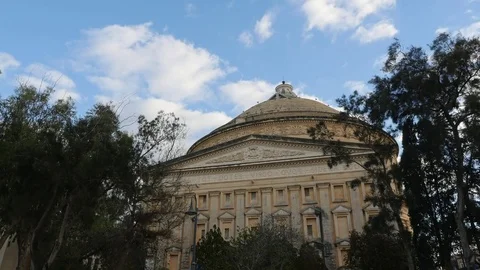 Timelapse of Mosta Dome framed by clouds overgead and trees Video stock 82167633