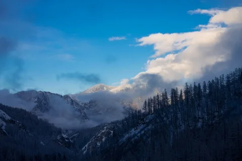 Timelapse motion of a cloud of fog rises into the sky in the snowy mountains Stock Footage 129002921