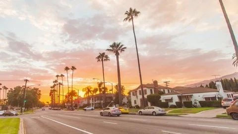 Timelapse in motion. Street hyperlapse at sunset with palm trees and cars Vídeo Stock 78520122