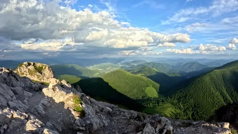 Timelapse of Mountain Range with Fast Clouds and Sunbeams Lighting Green Valleys Stock Footage 313870703