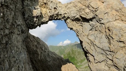 Timelapse of Mountain Ridges framed by Natural Arch in Fagaras Mountain Range Stock Footage 75429943
