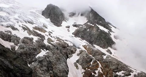 Timelapse of mountain surrounded by clouds in aerial view. We can see in the hor Video stock 137002642
