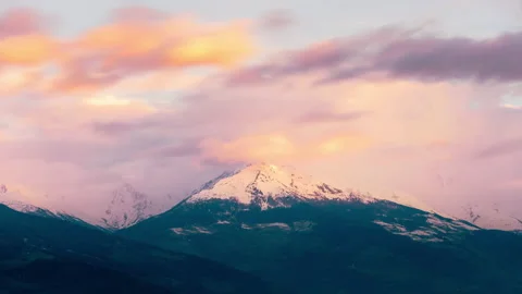 Timelapse of mountain top with clouds moving quickly at sunrise Stock Footage 265909618