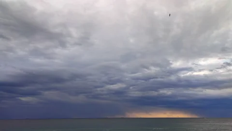 Timelapse. Movement of large dark rain clouds and rain on horizon over surface Stock Footage 212930636