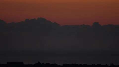Timelapse movement of the oblpkov over the sea and the roofs of the coastal Video stock 114420124