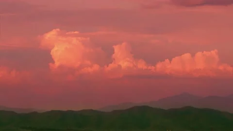 Timelapse. The movement of pink clouds in the sky on endless fields and hills Stock Footage 156899417