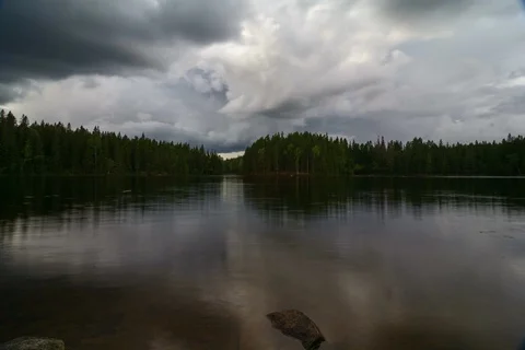 Timelapse of moving clouds and appoaching rain over a Swedish lake Stock Footage 93862293