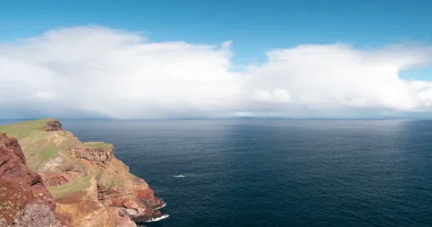 Timelapse with moving clouds and rainbow over the ocean in Madeira Stock Footage 231777389