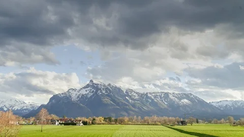 Timelapse of moving clouds with mountains and green meadows in the Alps Stock Footage 97835564