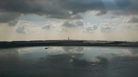 Timelapse of moving clouds over Milad Tower with reflections in water Stock Footage 317837731