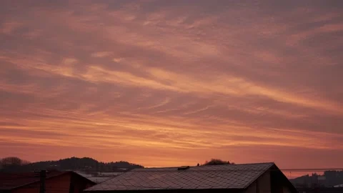 Timelapse of moving clouds at sunrise over the roofs of houses Stock-Footage 172319367