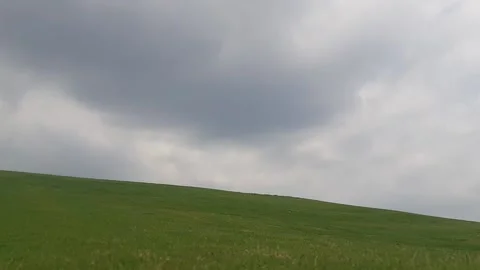 Timelapse moving dark clouds with green hills foreground Stock Footage 212360557